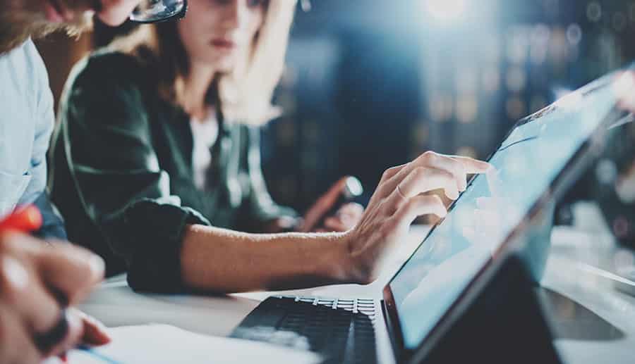 Woman looking at laptop deciding on business solutions.