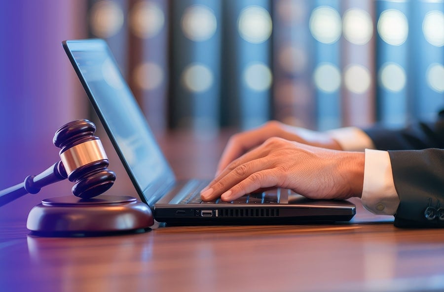 Online Legal Research Lawyer Typing on Laptop with Gavel Nearby
